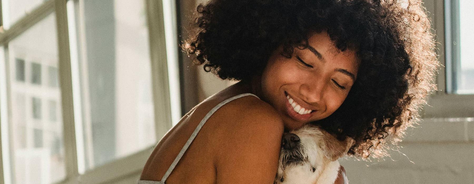 a girl on a bed hugging her dog