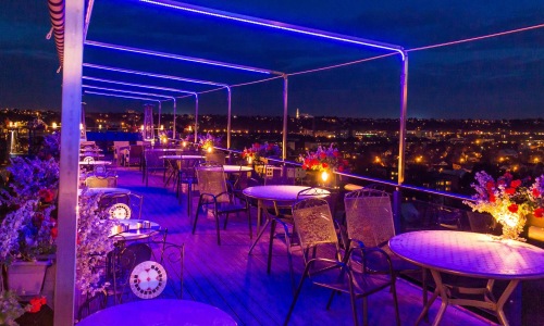 a group of tables and chairs on a rooftop terrace