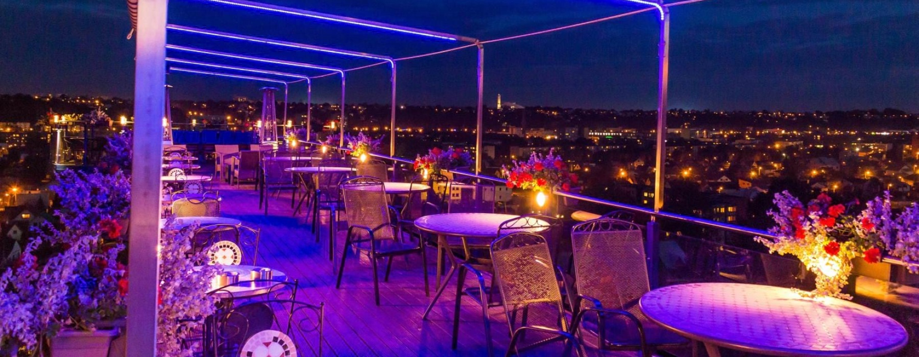 a group of tables and chairs on a rooftop terrace