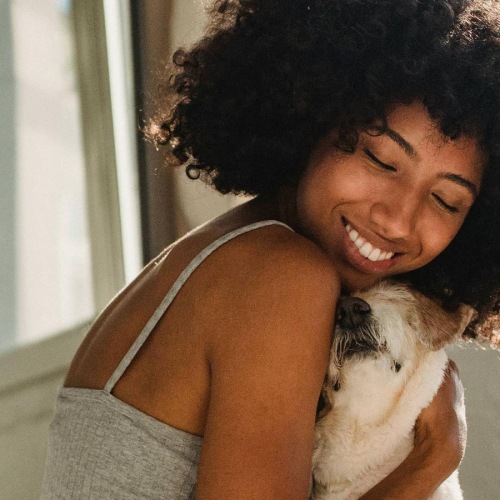 We're a pet friendly community a girl on a bed hugging her dog